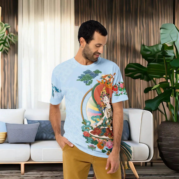 A man in a living room wearing a Cosmovisions-AI White Tara Thangka Men's t-shirt with an image of a buddha.